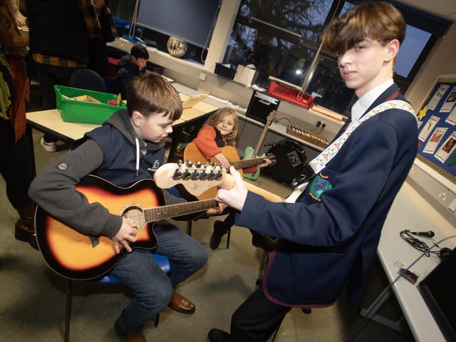Year 11 student Stephen Crawford showing some guitar chords to some of the prospective pupils from visiting schools.