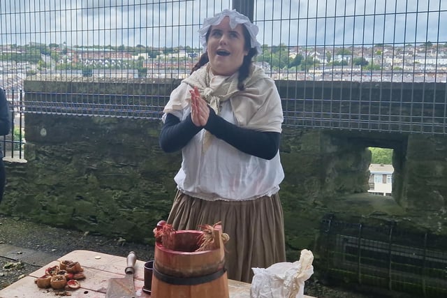 This character represented what was available to eat and drink inside the walls during the siege. The character offers up horse blood to drink. To eat she offered, rats, dogs, cats and horses.