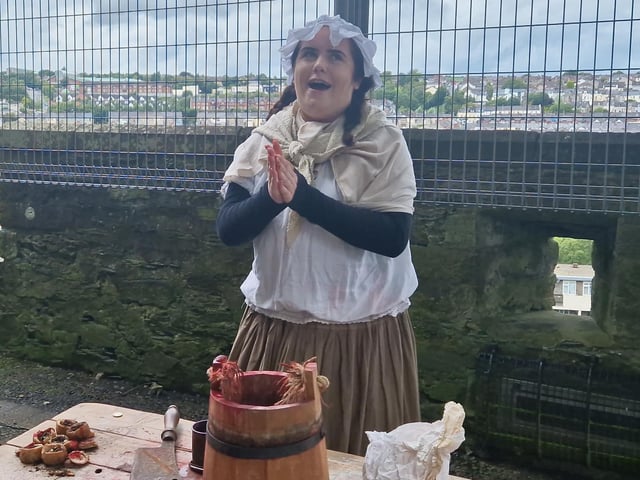 This character represented what was available to eat and drink inside the walls during the siege. The character offers up horse blood to drink. To eat she offered, rats, dogs, cats and horses.