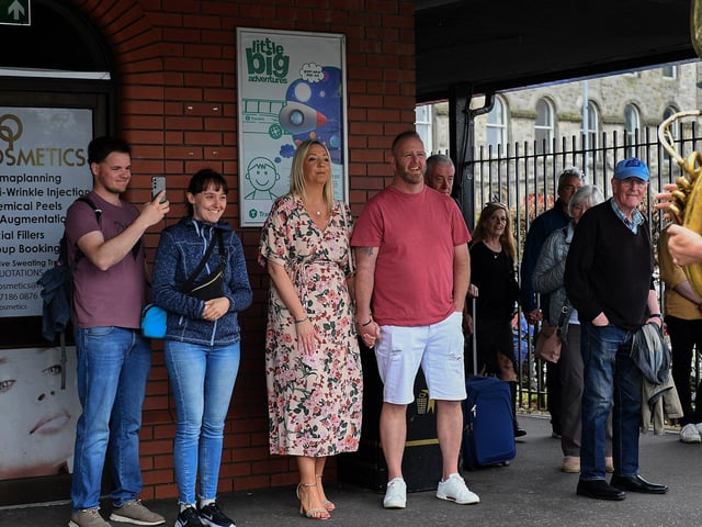Bus passengers watch the Jaydee Brass Band’s performance at the Foyle Street station on Friday afternoon. Photo: George Sweeney