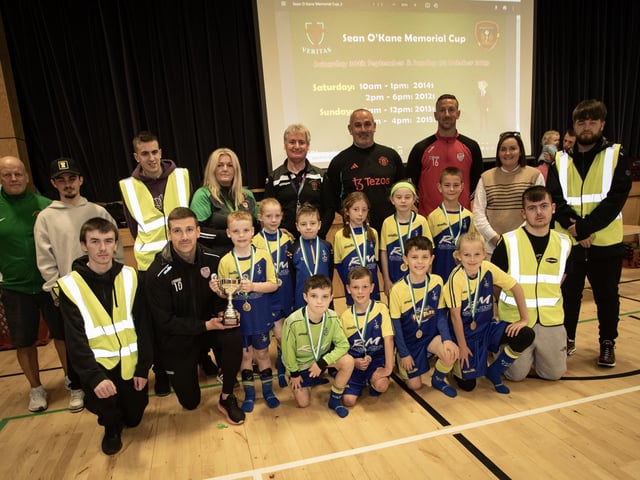 Derry City player Patrick McEleney presenting the winning trophy in the 2015 Sean O'Kane Memorial Cup to Elington Eagles on Sunday. Included are the winning team, event organisers, St. Joseph's Boys School and members of the O'Kane family. (Photos: Jim McCafferty Photography)