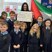 Roisin O'Hara, of Trócaire, receiving a cheque of £560 from pupils of Gaelscoil na Daróige