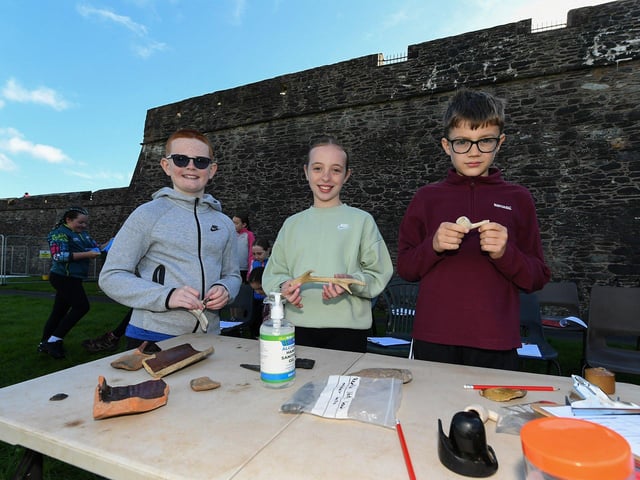 Gaelscoil Eadain Mhoir Paraic, Fiadh and Lorcan examine artifacts at the archaeology dig in an area beneath the City Walls. Photo: George Sweeney
