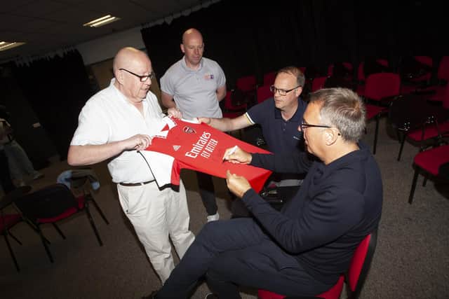 Old Library Trust chair Charlie O’Donnell gets an Arsenal jersey signed by Paul Merson on Monday evening. Included are George McGowan, Project Director, OLT and Derry Journal sports editor Michael Wilson.