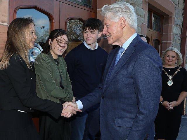 Bill Clinton is greeted by John Hume's grand daughter Rachel.