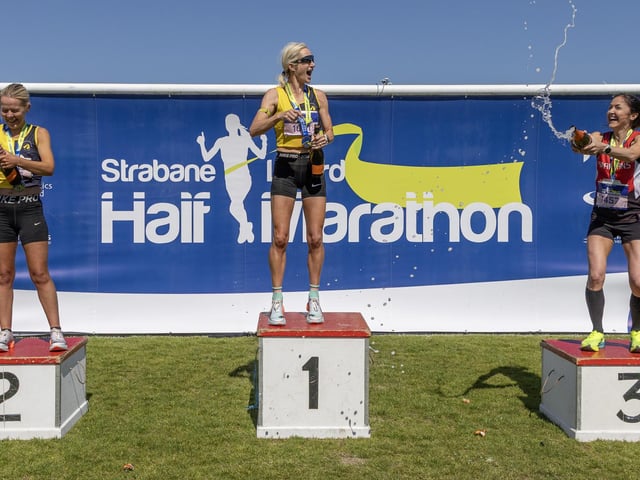 The top three female runners celebrate on the podium.