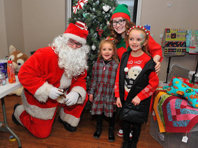 Posing for a picture with Santa at the Galliagh Community Response Christmas Craft Fair held in Pio House Parish Centre on Saturday, in aid of Foyle Down Syndrome Trust. Photo: George Sweeney. DER2250GS – 88