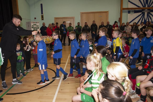 Derry City’s Cameron McJanett pictured handing out medals at St. Joseph’s Boys School on Sunday to Trojans FC.
