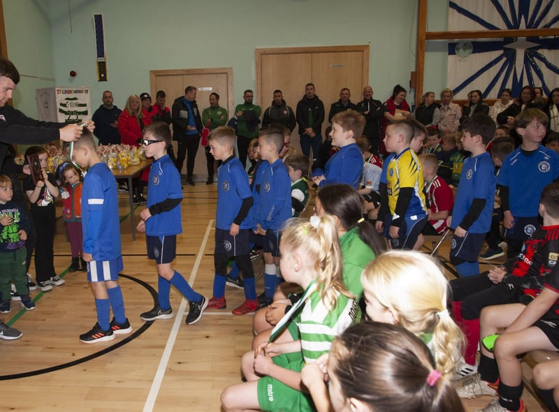 Derry City’s Cameron McJanett pictured handing out medals at St. Joseph’s Boys School on Sunday to Trojans FC.