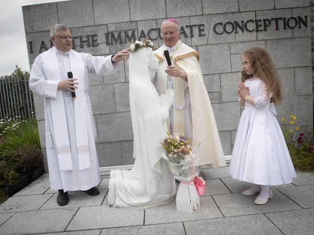 The Crown of Roses is blessed at the Grotto on Thursday.