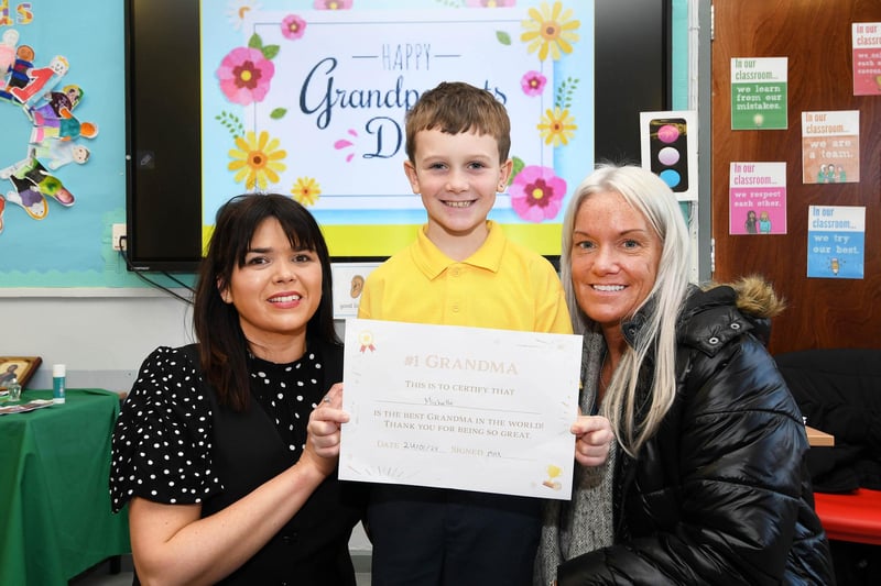 Primary 4 pupil Max presents Granny Michelle with a beautiful certificate. On left is Mrs. Catherine Doorish, Principal.