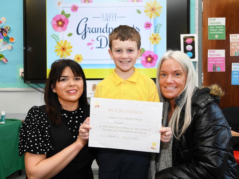 Primary 4 pupil Max presents Granny Michelle with a beautiful certificate. On left is Mrs. Catherine Doorish, Principal.