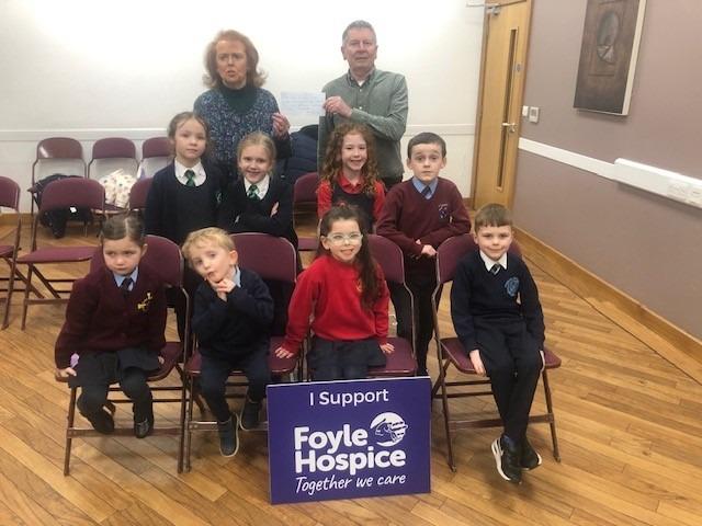 Una O’Somachain (McCafferty school of Music)  presenting a cheque for £300 to Noel McMonagle, Foyle Hospice, proceeds of a recent McCafferty school of music performance by the children.