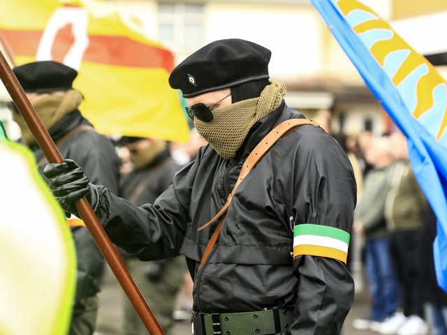 Members of the Colour Party lower the flags as a salute to dead comrades at the Creggan Republican monument as they take part in the Saoradh Easter Commemoration leaving Creggan Shop to City Cemetery. (Photo - Tom Heaney, nwpresspics)