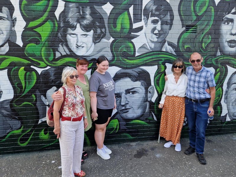 Members of Jim Wray's family alongside his portrait.