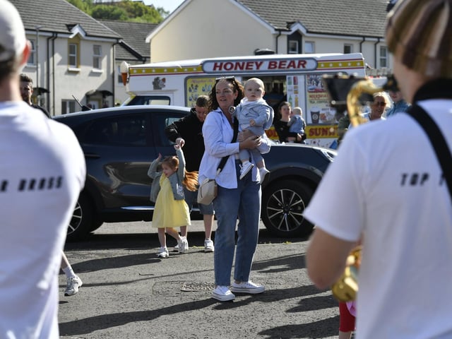People enjoy the sunshine and the sounds of the Top Tier Brass Band playing in Meenan Square. Photo: George Sweeney