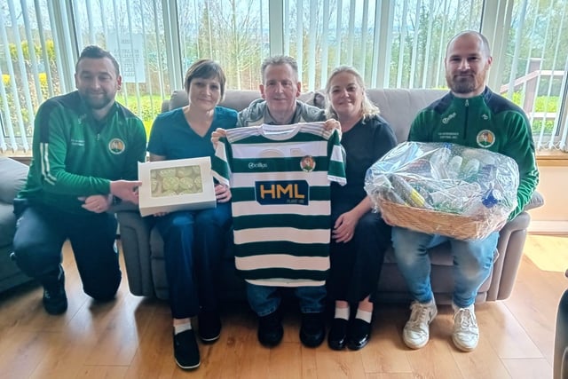 Peter Doherty and Gavin Cullen from Cockhill Football Club presenting a Well Being Hamper and cup cakes to Lucy McGettigan and Catalina Arionesei . Also pictured is Martin O'Donnell.
