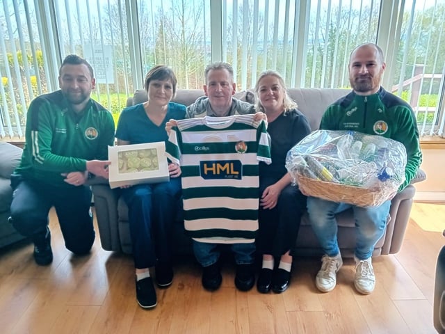Peter Doherty and Gavin Cullen from Cockhill Football Club presenting a Well Being Hamper and cup cakes to Lucy McGettigan and Catalina Arionesei . Also pictured is Martin O'Donnell.