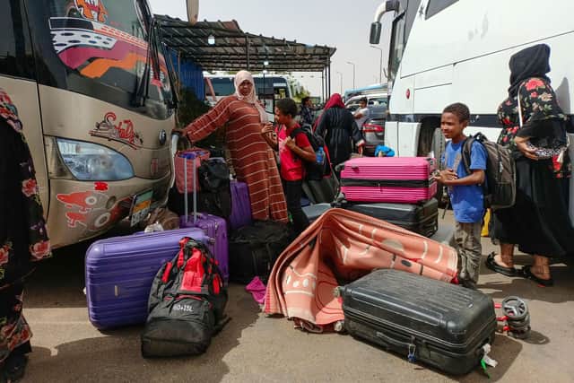 TOPSHOT - Passengers fleeing war-torn Sudan disembark at the Wadi Karkar bus station near the Egyptian city of Aswan, on April 25, 2023. (Photo by AFP) (Photo by -/AFP via Getty Images)
