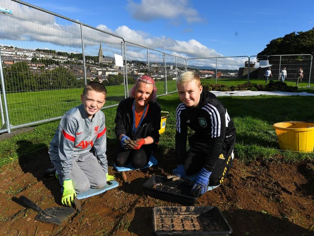Gaelscoil Eadain Mhoir Múinteoir Alicia O’Kane and pupils Cahir McGinley and Cian Green pictured at the Queen’s University Centre for Community Archaeology dig in an area beneath the City Walls. Photo: George Sweeney