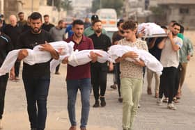 Members of the al-Zanati, family killed following an Israeli strike, are taken to a waiting vehicle to be driven to a cemetery for burial in Khan Yunis on October 23, 2023. (Photo by MAHMUD HAMS / AFP)