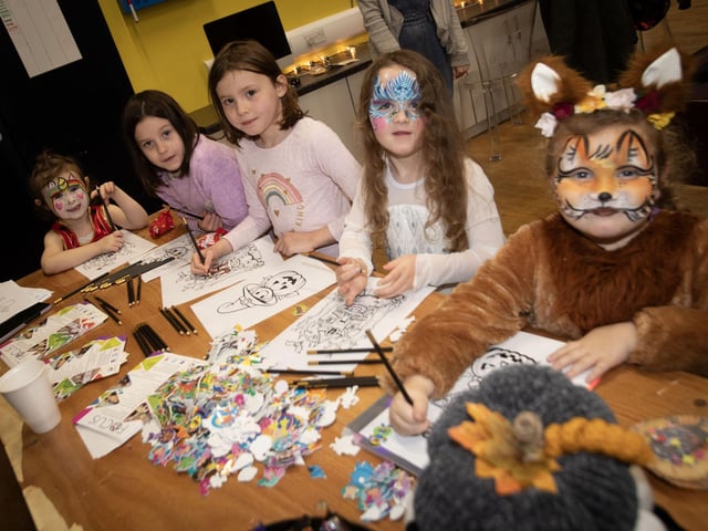 Children enjoying some colouring-in at the Feile/Surestart (Edenballymore) Halloween Fun Day at the Long Tower Youth Club on Monday afternoon.