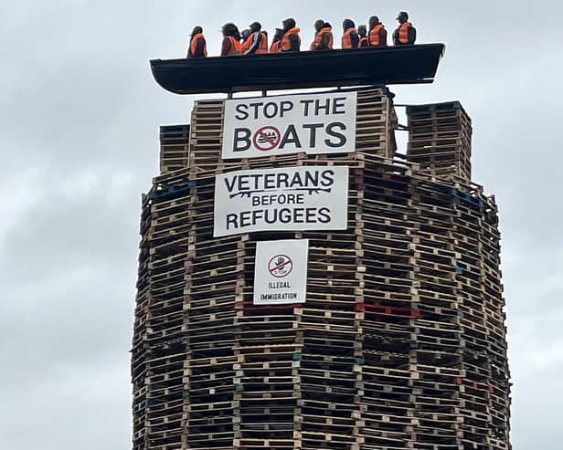 Models depicting migrants wearing life jackets in a small boat alongside two banners reading 'Stop the boats' and 'Veterans before refugees' are displayed on top a bonfire in Moygashel, Northern Ireland, on July 9, 2025. The model has prompted condemnation and calls for its removal before the pyre is lit on July 11. Last month anti-immigration riots erupted in loyalist areas around the British province after an alleged rape of a minor in the town of Ballymena north of Belfast. (Photo by Peter MURPHY / AFP) (Photo by PETER MURPHY/AFP via Getty Images)