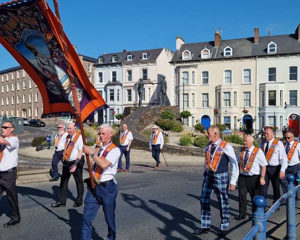Orangemen passing Derry's Hands Across the Divide sculpture.
