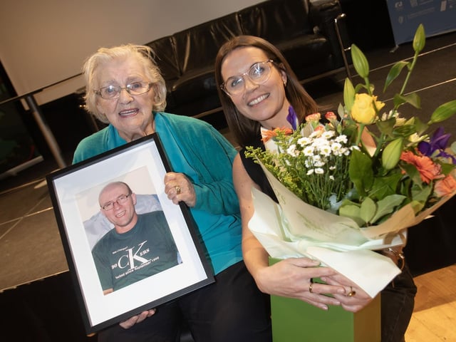 Mary Nelis receiving a bouquet of flowers at her son's memorial lecture.