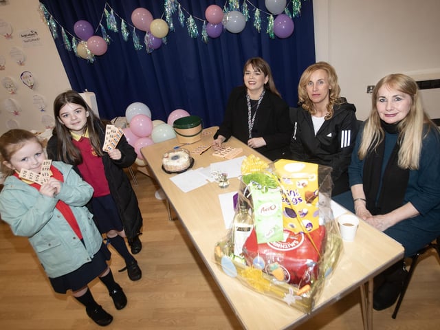Catherine Doorish, Principal, Steelstown PS (centre) pictured at the school's Coffee Morning in aid of Angel Wishes on Friday morning. Buying tickets are pupils Georgi White and Farrah McFarland. On right are Bernie Fox and Cass McGlynn. (Photos: Jim McCafferty Photography)