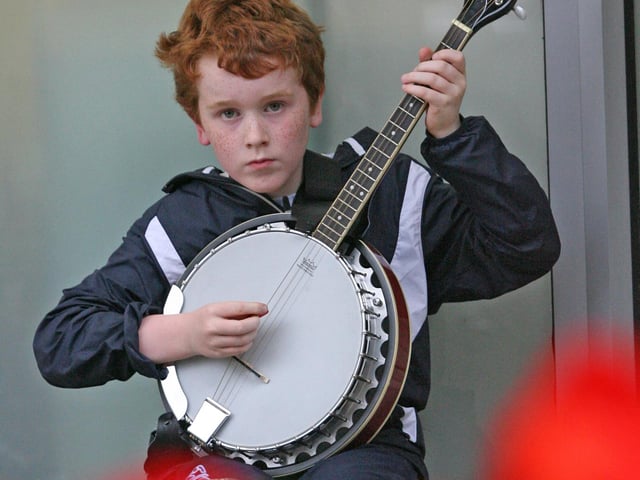 9 years-old banjo player Daragh Grady from Mayo, pictured playing on Strand Road on Thursday afternoon during the Fleadh celebrations. DER3313JM087