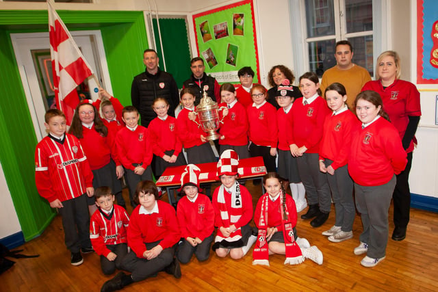 P6 pupils at St. Eugene’s PS show their support for Derry City on Monday last as players Shane McEleney and Joe Thompson brought the FAI Cup to the school.