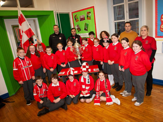 P6 pupils at St. Eugene’s PS show their support for Derry City on Monday last as players Shane McEleney and Joe Thompson brought the FAI Cup to the school.