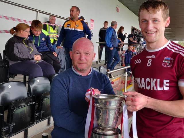 Slaughtneil captain Brendan Rogers freceives the Fr. Collins Cup after his side's victory over Kevin Lynch's in Owenbeg on Sunday.