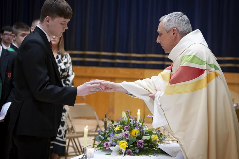 Year 12 student Niall Derges-Bonner handing over a candle to represent 12B to Fr Paul Farren during Friday’s St. Joseph’s Year 12 Leavers Mass in the school.