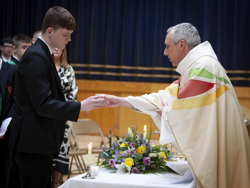 Year 12 student Niall Derges-Bonner handing over a candle to represent 12B to Fr Paul Farren during Friday’s St. Joseph’s Year 12 Leavers Mass in the school.