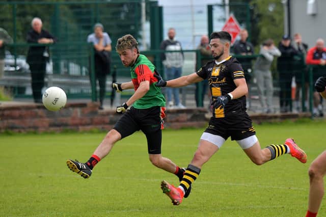 Doire Trasna’s Connell Guille fends off a challenge from Moneymore’s Aaron Moore.  Photo: George Sweeney. DER2331GS – 92