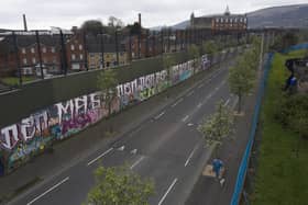 BELFAST, NORTHERN IRELAND - APRIL 03, 2023. A local resident walks along the so called peace wall on April 3, 2023 in Belfast, Northern Ireland. The Good Friday Agreement, signed on April 10, 1998, ended most of the violence during the decades-long conflict known as The Troubles. The Peace Walls protect the communities from attacks from one another, some have been removed but in some instances other walls have become higher and longer since the Good Friday Agreement. (Photo by Charles McQuillan/Getty Images)