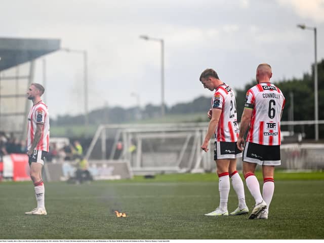 Derry City players, from left, Carl Winchester, Sam Todd and Mark Connolly after a flare was thrown onto the pitch