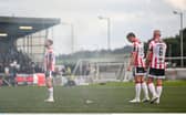 Derry City players, from left, Carl Winchester, Sam Todd and Mark Connolly after a flare was thrown onto the pitch