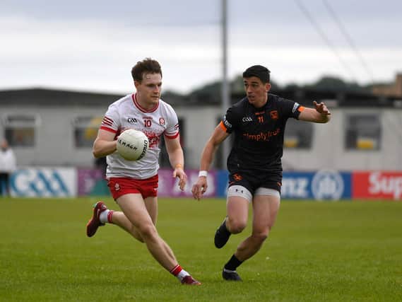 Derry’s Ethan Doherty slips a tackle from Rory Grugan of Armagh. Photo: George Sweeney