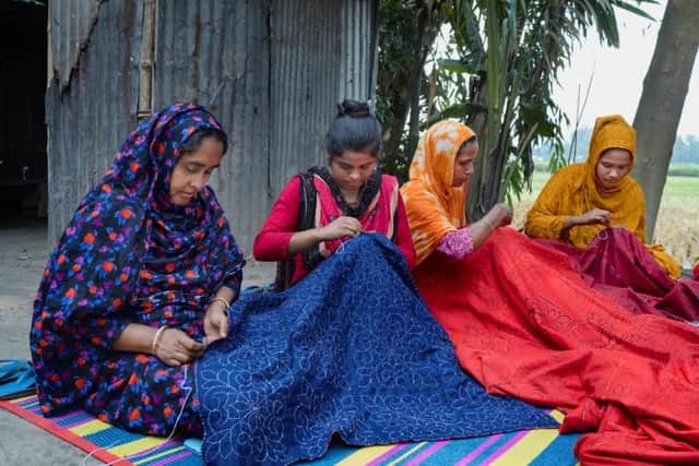 Caption: Kakoli Khatun (2nd from left) and other women supported by Christian Aid’s local partner are earning an income by keeping alive the tradition of nakshi kantha, the centuries-old Bengali art of quilt-making which involves embroidering old saris with thread. Credit: Fabeha Monir/Christian Aid