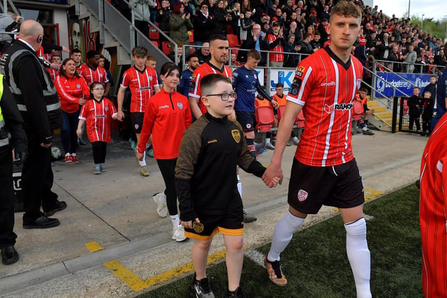 Derry City players, with mascots, walk out for kick-off against St Patrick’s Athletic on Friday evening. DER2317GS-93A