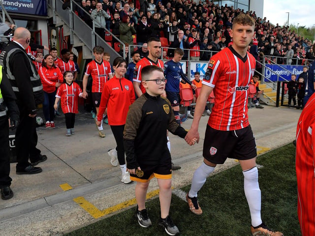 Derry City players, with mascots, walk out for kick-off against St Patrick’s Athletic on Friday evening. DER2317GS-93A