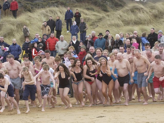 The huge crowd of swimmers at Caratra Beach, Culdaff, head for the water to raise money for the Carndonagh Alzhiemers Unit and Culdaff Youth Club. (0301PG01) : Culdaff New Year's Day Swim in 2006.