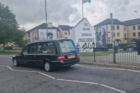 Nell McCafferty's funeral cortege passes Free Derry Corner on Friday.