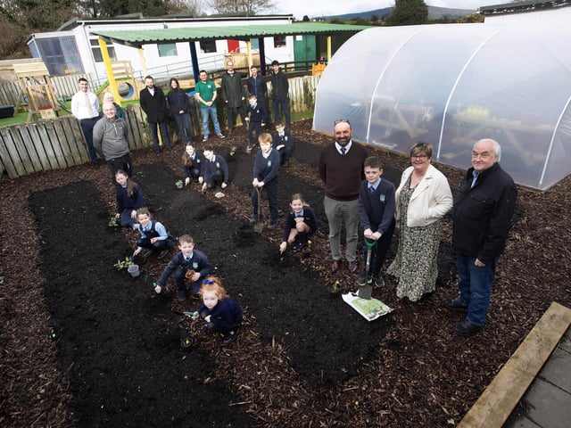 BIG GARDEN LAUNCH AT HOLLYBUSH PS. . . . .Pupils from Hollybush PS cutting the ribbon to officially open their new polytunnel and launch their new food growing garden project supported by Natural World Products (NWP). Included in photo are Colum Eastwood Foyle MP, Mark Durkan MLA, Colm Warren NWP, Feargal Friel, Acting Principal, Cahir O'Connor, Vice Principal, Gareth Lamrock, ECO Schools Education Officer, Allan Bogle Acorn Farm, Sharon McMaster Community Outreach Manager and Horticulturist for NWP, Patricia McCormick, After-School Garden Club Facilitator, Andy McDermott, school caretaker and board of governors representatives Paul Kirby and Angela Dobbins. (Photos: Jim McCafferty Photography)
