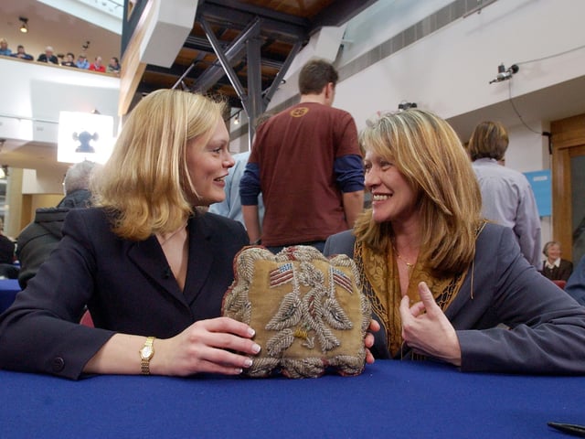 An antiques expert examines one of the items.