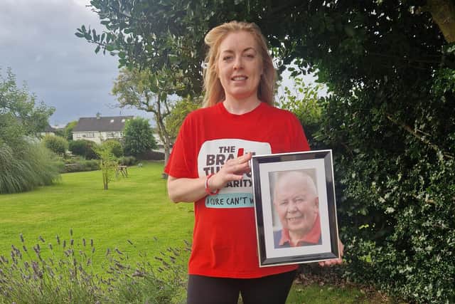 Helena Lamrock holds a picture of her late father-in-law Willie Lamrock.