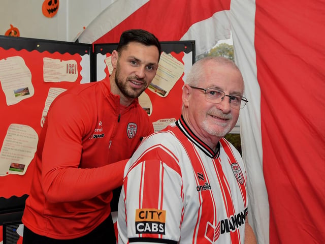 Derry City striker Pat Hoban signs a shirt for Múinteoir Antoin de Brún during a visit to Gaelscoil Eadain Mhoir on Monday morning. Photo: George Sweeney